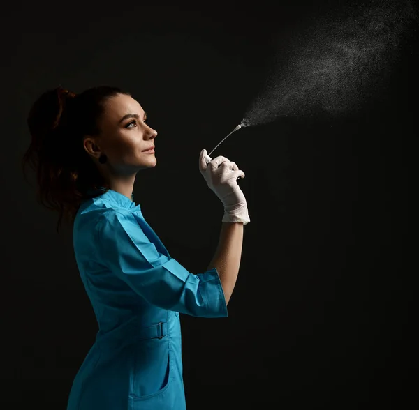 Jolie brune femme médecin gynécologue infirmière en latex gants et uniforme médical robe utilise désinfectant spray — Photo