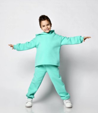Modern yeşil, nane rengi kapüşonlu şık saç kesimi olan genç, aktif, pozitif çocuk el ele tutuşup duruyor.