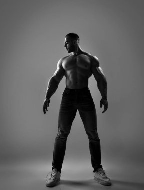 Yakışıklı, kaslı, güçlü vücut geliştirici haltercinin siyah beyaz portresi.