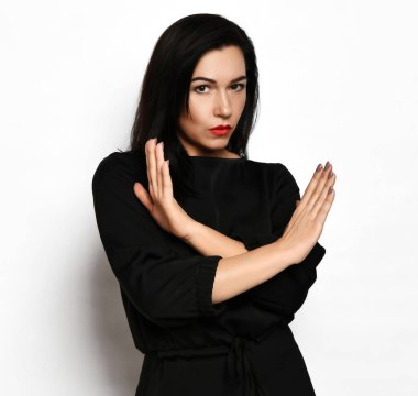 Sert, sert görünüşlü, hoş esmer, şık, siyah elbiseli kadın kollarında haç işareti yok.