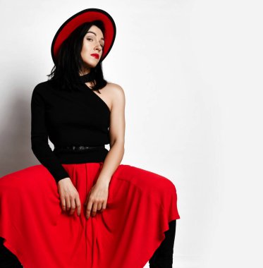 Modern siyah kolsuz tişörtlü, geniş bacaklı, maksimum etekli, şık seksi yetişkin kadın portresi.