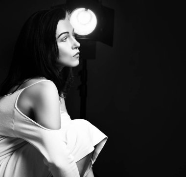 Düşünceli, olgun, güzel, esmer bir kadının siyah beyaz portresi yan yana oturmuş fotokopi odasına bakıyor.