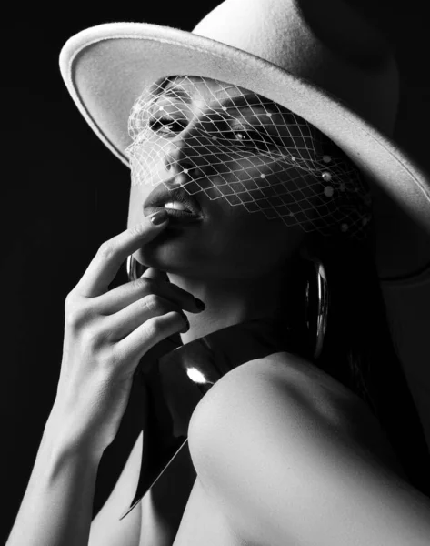 Black and white portrait of rich gorgeous woman in wide-brimmed white hat with veil and massive metal collar, earrings — Stock Photo, Image