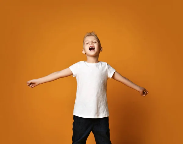 Retrato de colegial, adolescente en pantalones vaqueros azules y blanco en blanco camisetas de pie sosteniendo los brazos extendidos y cantar — Foto de Stock