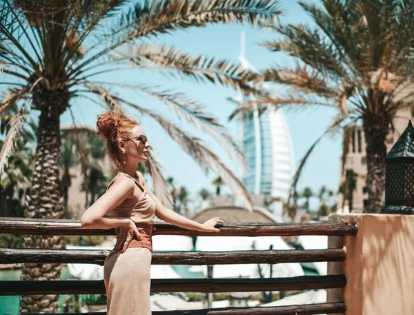 Rijke luxe toeristische vrouw in de zomer jurk is genieten van sightseeing tour tijdens vakantie in Dubai in de Verenigde Arabische Emiraten — Stockfoto