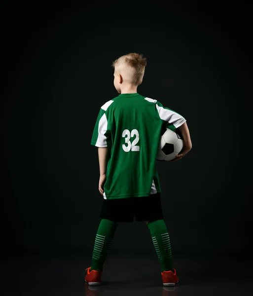 Jovem jogador de futebol, estudante de escola, adolescente em vermelho branco listrado uniforme fica de volta para câmera segurando bola — Fotografia de Stock