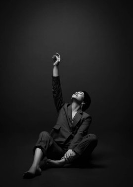 Genç, kısa saçlı, esmer, iş kadını, şık, rahat takım elbiseli, el ele tutuşup, dokunuyor.