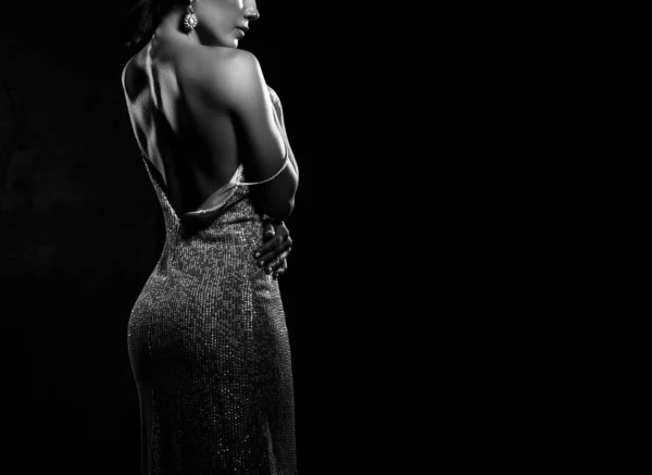 Silhouette of Sexy beautiful young woman in silver cocktail dress standing and showing her body lines — Stock Photo, Image