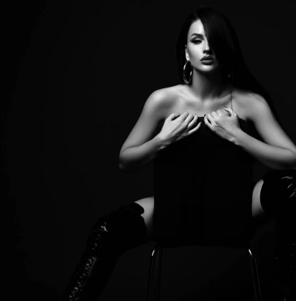 Sexy brunetka nagie piękne kobieta model w wysokie buty siedzi na krzesło ukrywanie ciało — Zdjęcie stockowe