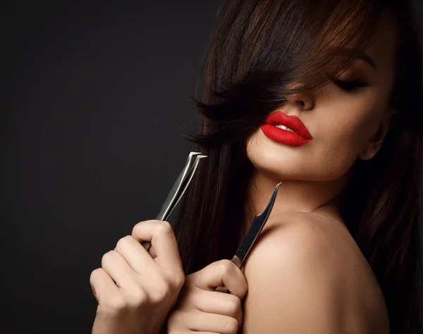 Portré érzéki barna nő kozmetológus modell piros ajkak gazdaság csipeszek szempilla és homlokát, hogy a kezében — Stock Fotó