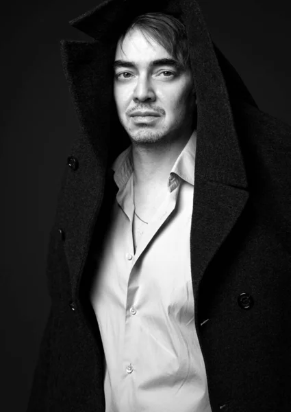 Черно-белый портрет взрослого мужчины-поэта, писателя в белой рубашке и пальто на голове — стоковое фото