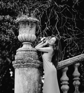 Genç, zayıf, şehvetli kadın turistin siyah beyaz portresi antik merdivenlerde bale, taş saksı