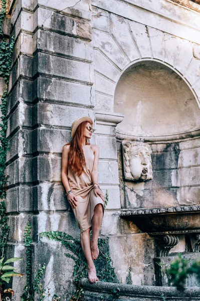 Touristin im Sommerkleid steht barfuß auf Balkonbrüstung des alten Palastes, Brüstung genießt Besichtigung — Stockfoto