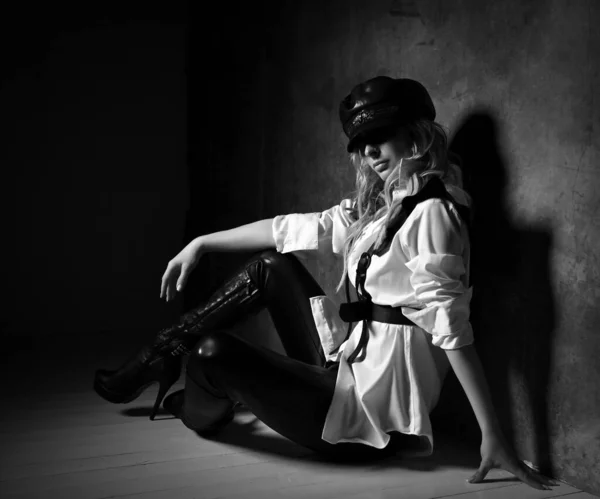 Piękne sexy młody blondynka kobieta model w biały koszula czarny spodnie i skóra akcesoria wysokie buty siedzi na podłodze — Zdjęcie stockowe