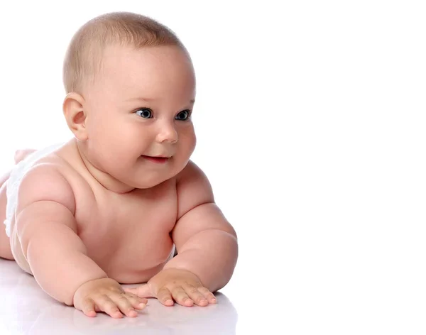 Porträtt av glad spädbarn barn flicka unge i blöja liggande på magen, mage tittar åt sidan på kopieringsutrymme — Stockfoto