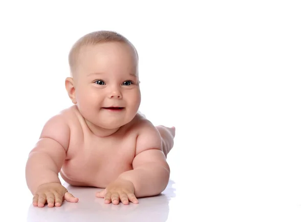 Happy infant child baby girl kid in diaper lying on her tummy, stomach, crawling, touching floor at copy space — Stock Photo, Image
