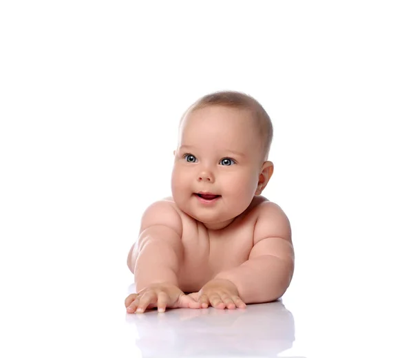 Happy, surprised, amazed infant child baby girl kid in diaper is lying on her stomach holding arm outstretched — Stock Photo, Image