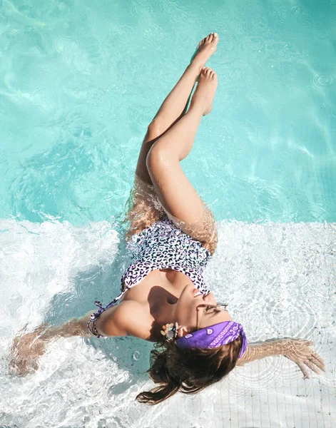 Jonge sexy vrouw met grote borst in witte luipaard print bikini ligt, neemt rust, ontspannen, in het zwembad helder water — Stockfoto