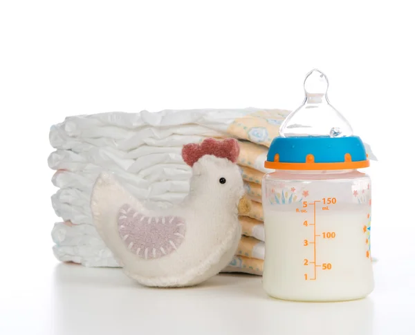 New born child composition stack of diapers toy and baby feeding — Stock Photo, Image