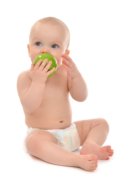 Bambino felice bambino seduto in pannolino e mangiare mela verde — Foto Stock