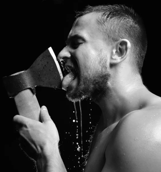 Bearded young man lick big axe foam and water splashes — Stock Photo, Image