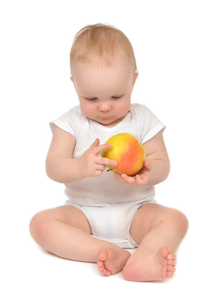 Happy child baby boy sitting in diaper and eating red yellow app — Stock Photo, Image