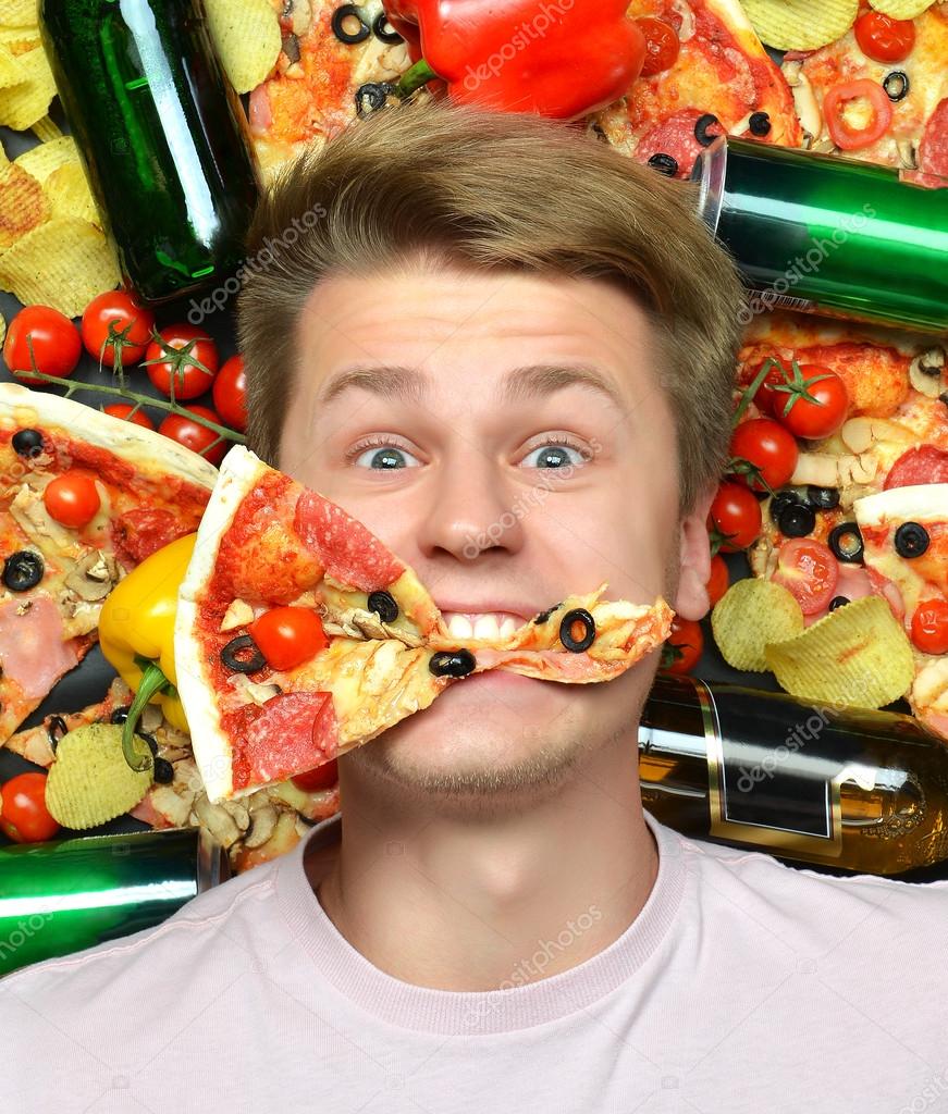 Man lying down with slice of pizza in mouth Stock Photo by ©dml5050 56540739