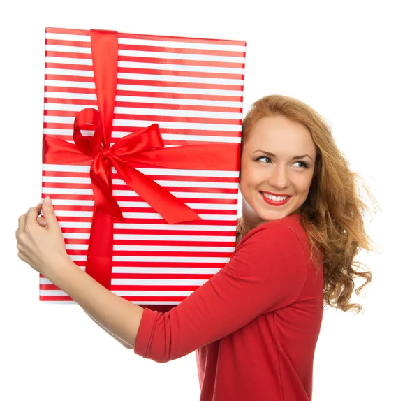 Glückliche junge Frau hält rotes weihnachtlich verpacktes Geschenk-Smilin in der Hand — Stockfoto