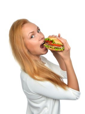 Fast food concept. Woman eating tasty unhealthy burger sandwich clipart