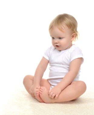Halı üzerinde oturan ve aşağı bakıyor bebek çocuk bebek yürümeye başlayan çocuk