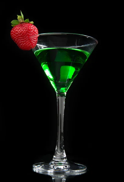 Зеленый коктейль абсент украшен красной клубникой в мартини — стоковое фото
