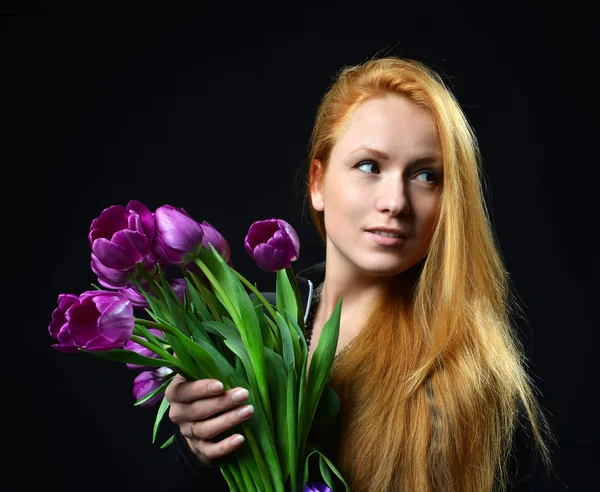 Beautiful redheaded girl hold bouquet of purple tulips flowers — Stock Photo, Image