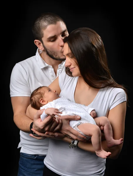 Мать и отец улыбаются, держа в руках новорожденного детеныша — стоковое фото