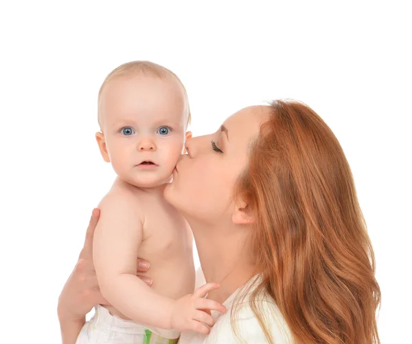 Женщина держит и целует на руках новорожденного младенца — стоковое фото