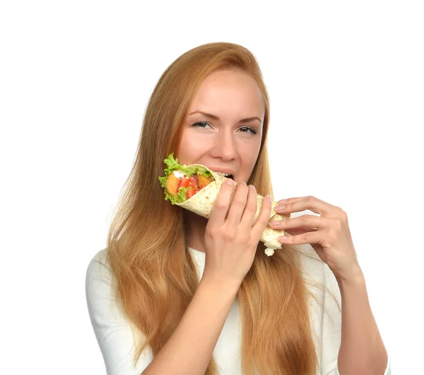 Kvinnan äter välsmakande ohälsosamma burger twisted smörgås i händer — Stockfoto