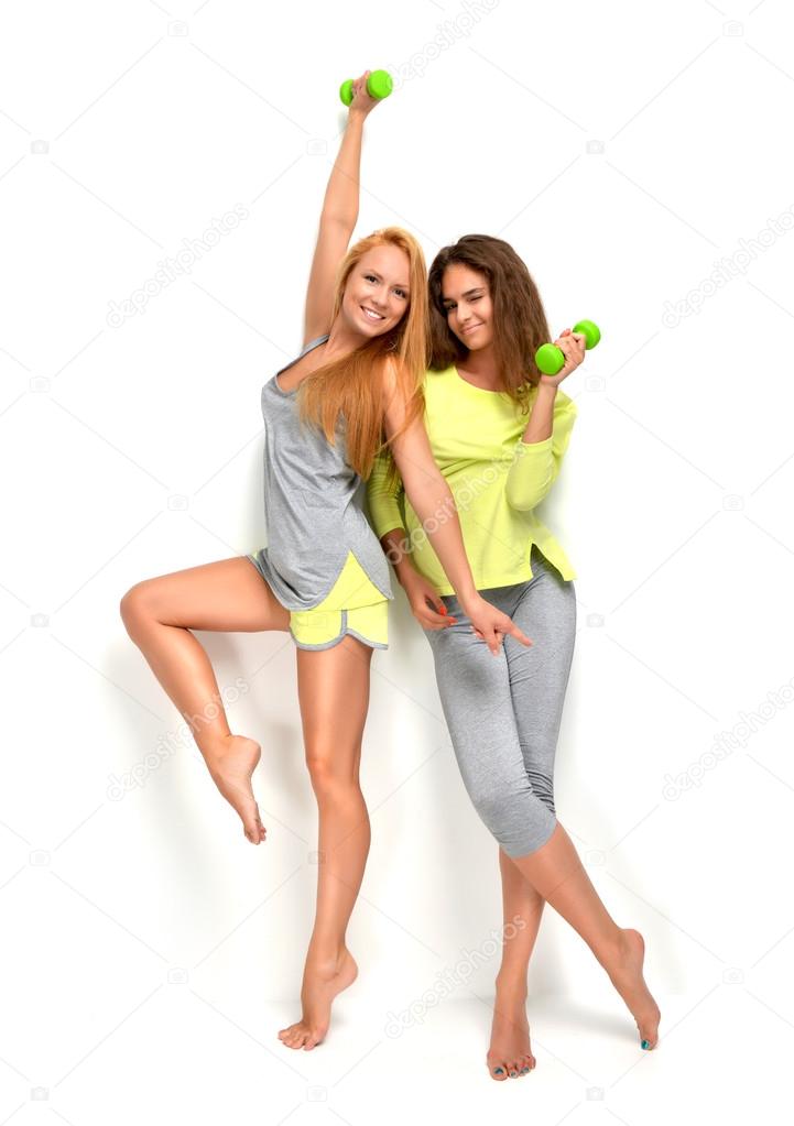 sports women smiling laughing hugging with green fitness dumpbel