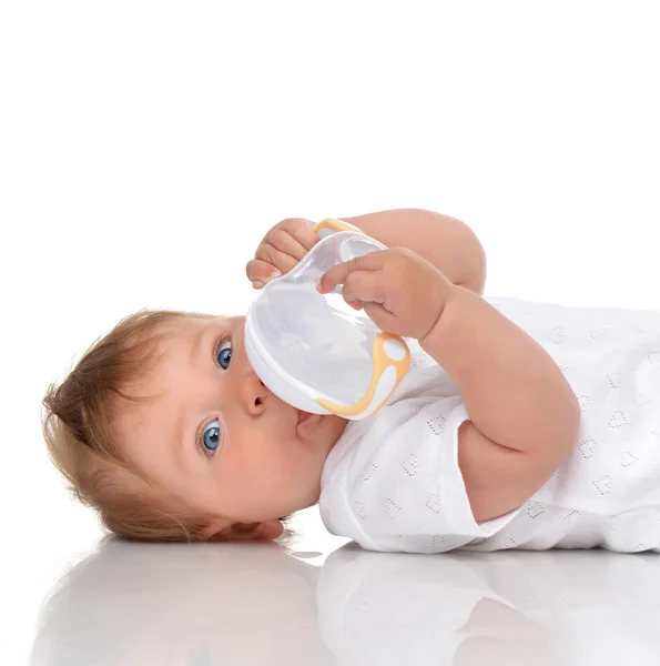 Infant child baby kid lying and drinking water from the feeding — Stockfoto