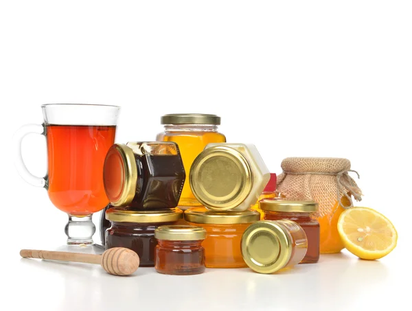 Tasty jars of jam and honey cream lemon and tea — Stock Photo, Image