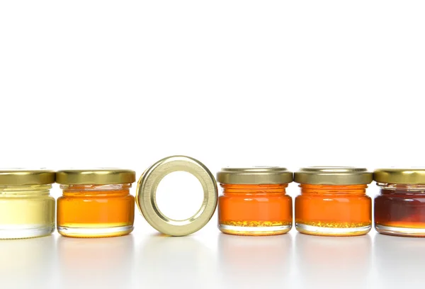 Tasty jars of jam and honey in a row with blank text space — Stock Photo, Image