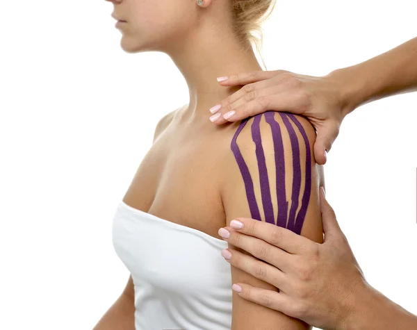 Доктор руки наносять спеціальну стрічку фізіо на жіноче плече — стокове фото