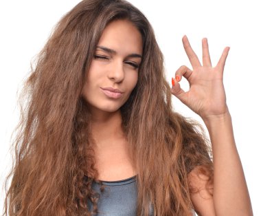 Happy smiling sly beautiful brunette young woman showing ok good