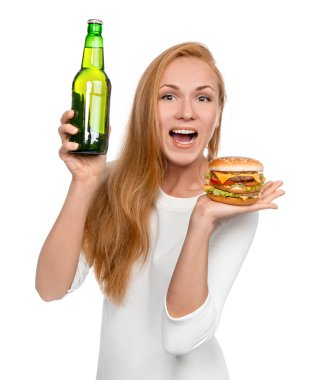 Woman hold tasty unhealthy burger sandwich in hand and bottle of