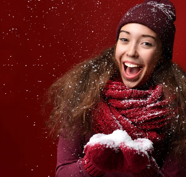 Chica joven feliz en sombrero de invierno sonriendo bajo el clima nevado — Foto de Stock