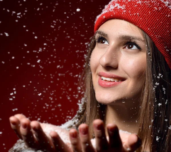 Chica joven feliz en sombrero de invierno sonriendo bajo el clima nevado — Foto de Stock