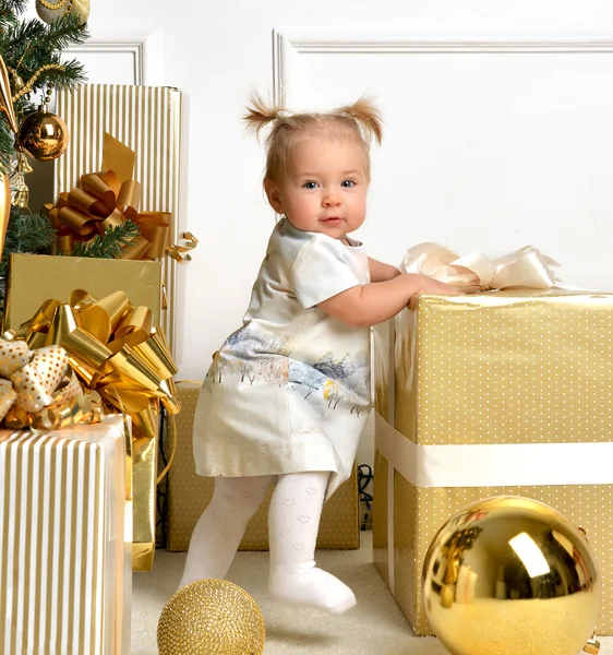 Niño de Navidad niño cerca de árbol de navidad de oro presenta un — Foto de Stock