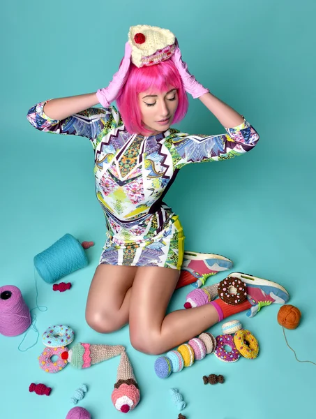 Woman in hot pink party wig holding fake candy cake on head and — Stock Photo, Image