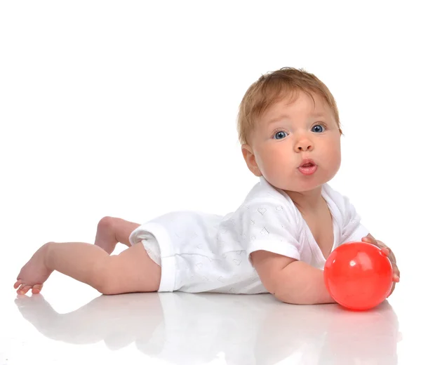 Infant child baby boy toddler playing with red ball toy in hands — Stockfoto