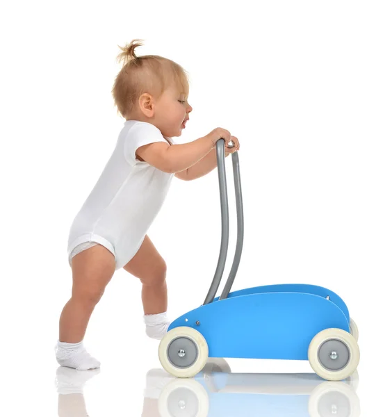 Söta leende baby flicka småbarn med leksak walker gör första stegen — Stockfoto