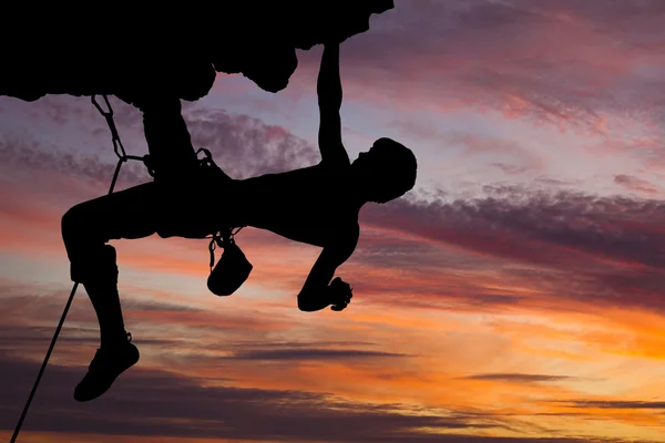 Silhouette of a rock climber on a rock against a beautiful sky.