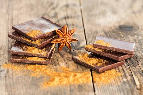 Table en bois de chocolat entourée d'épices . — Photo